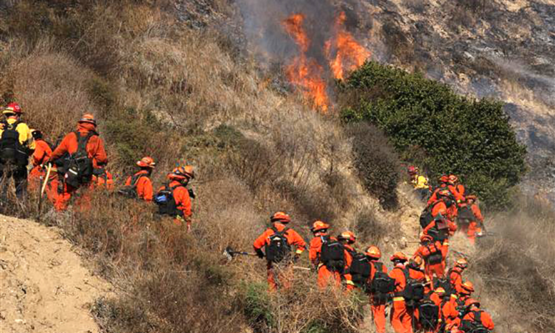 Lính cứu hỏa nỗ lực dập lửa cháy rừng tại Malibu, California, Mỹ. Ảnh: THX/TTXVN