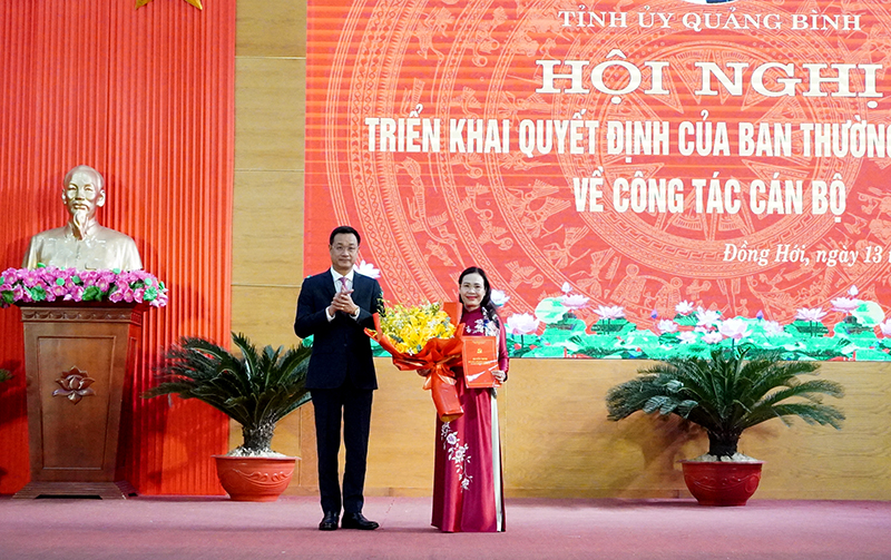 Đồng chí Bí thư Tỉnh ủy Lê Ngọc Quang trao quyết định và tặng hoa chúc mừng đồng chí tân Bí thư Thành ủy Đồng Hới Phạm Thị Hân.
