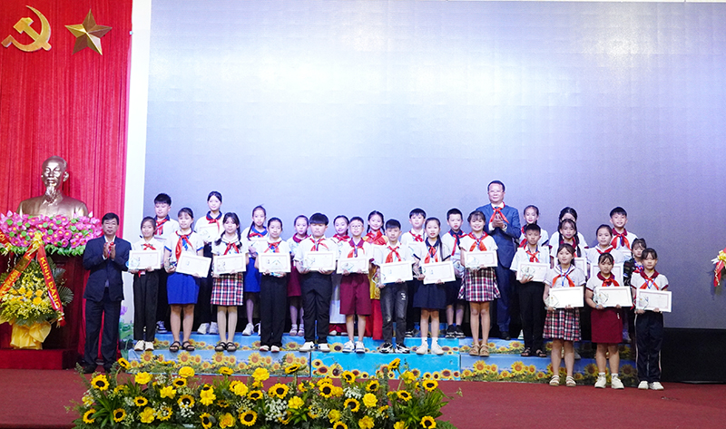 Đại diện lãnh đạo huyện Bố Trạch, Hội đồng Đội tỉnh trao tặng biểu trưng và giấy chứng nhận “Cháu ngoan Bác Hồ” cho các đội viên tiêu biểu.