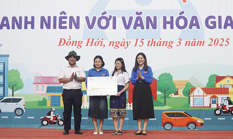 Trao biển tượng trưng tặng mũ bảo hiểm cho các hoàn cảnh khó khăn.