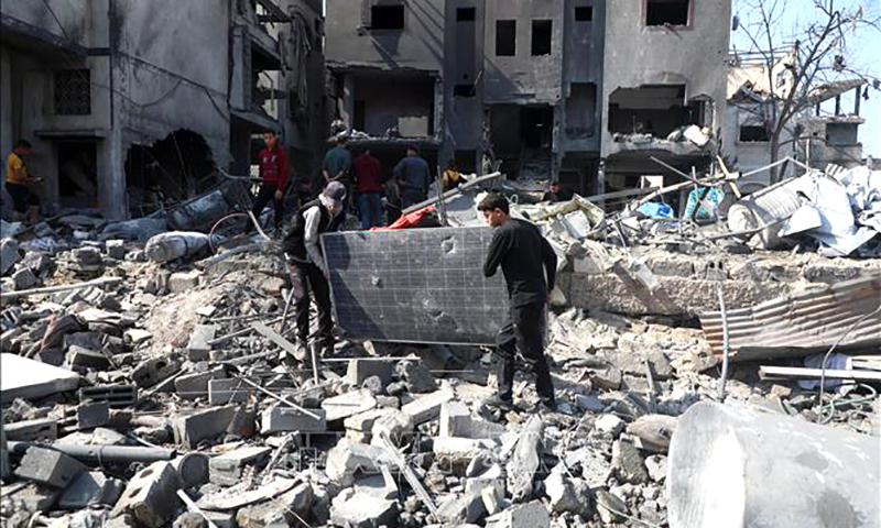Người dân dọn đống đổ nát sau các cuộc không kích của Israel tại Dải Gaza ngày 18/3/2025. Ảnh: THX/TTXVN