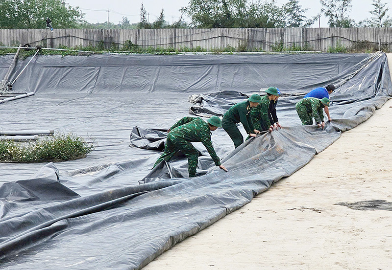 Cán bộ, chiến sỹ Đồn Biên phòng Nhật Lệ hỗ trợ hộ ông Nguyễn Ngọc Thanh (xã Hải Ninh) tháo dỡ công trình nằm trong phạm vi dự án.