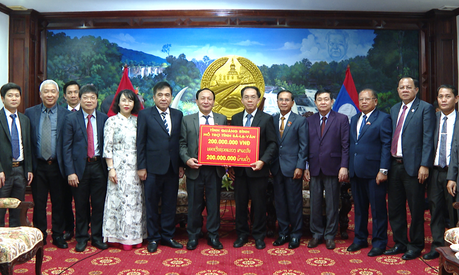 Đồng chí Phó Bí thư Thường trực Tỉnh ủy Trần Hải Châu trao tặng số tiền 200 triệu đồng cho tỉnh Chăm-pa-sắc để thực hiện công tác an sinh xã hội.