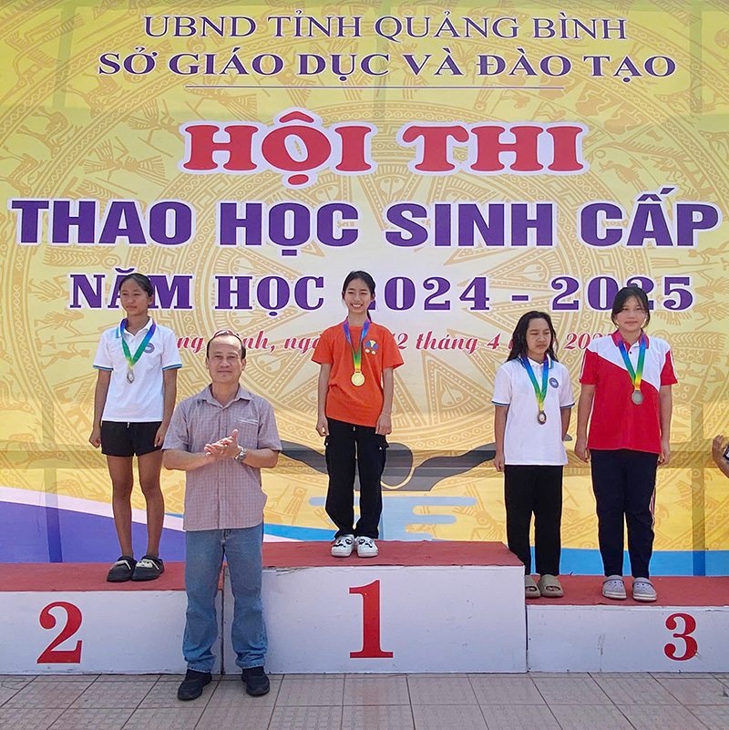 Ban tổ chức trao huy chương cho các vận động viên đạt thành tích cao.