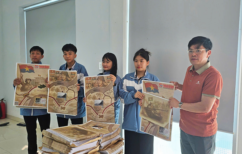 Đại diện Báo Nhân Dân tặng phụ san đặc biệt cho các em học sinh.