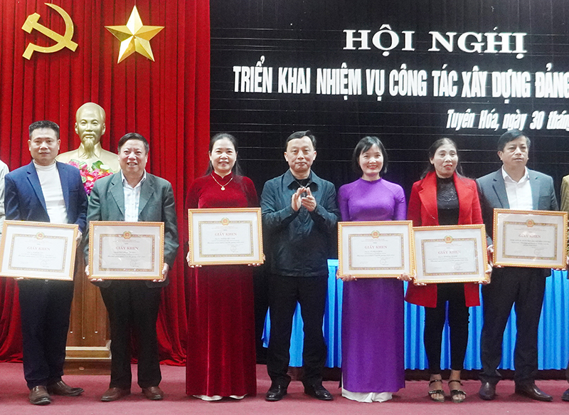 Bí thư Chi bộ, Hiệu trưởng Trường THCS Kim Hóa Phạm Minh Tâm (ngoài cùng bên phải) nhận giấy khen của Ban Thường vụ Huyện ủy Tuyên Hóa về thành tích  