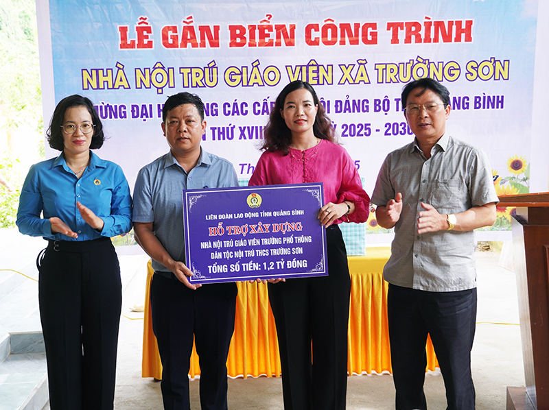  Đại diện lãnh đạo LĐLĐ tỉnh và huyện Quảng Ninh trao biển tượng trưng hỗ trợ kinh phí xây nhà nội trú giáo viên xã Trường Sơn.