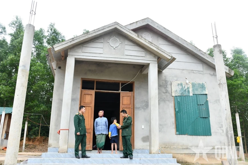 Bà Hồ Thị Đanh cùng cán bộ Đoàn Kinh tế-Quốc phòng 337 bên ngôi nhà mới ở khu tái định cư Sê Pu (xã Hướng Lập, tỉnh Quảng Trị).