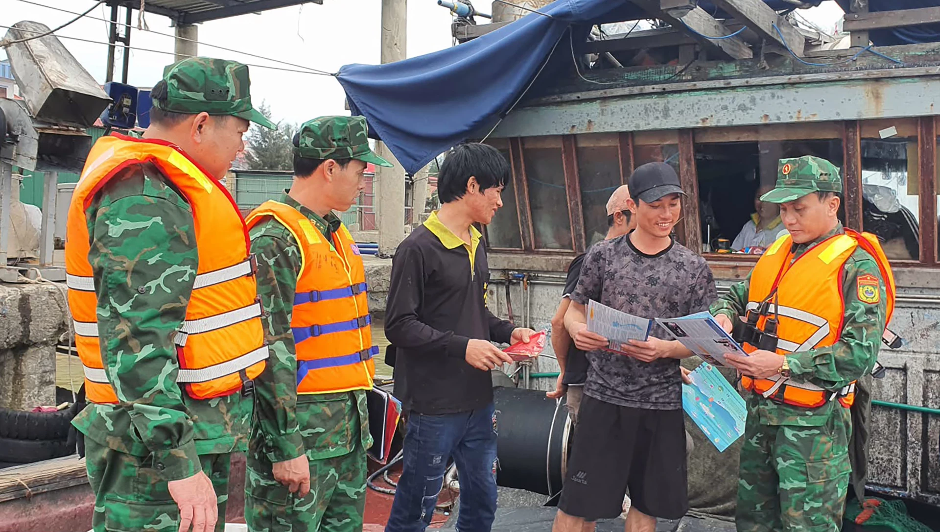 Cán bộ, chiến sĩ Đồn Biên phòng Cửa khẩu Cảng Gianh tuyên truyền chống khai thác IUU cho ngư dân - Ảnh: N.M