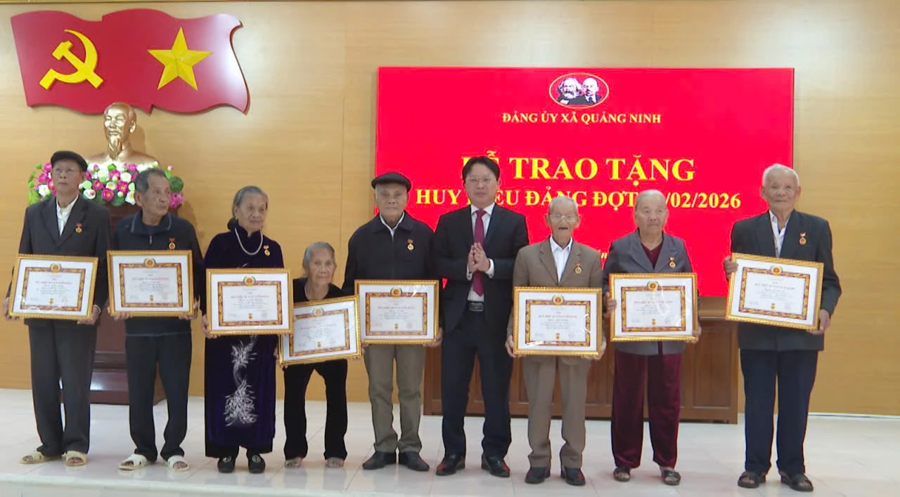 Lãnh đạo xã Quảng Ninh trao Huy hiệu Đảng cho các đảng viên -Ảnh: ĐN