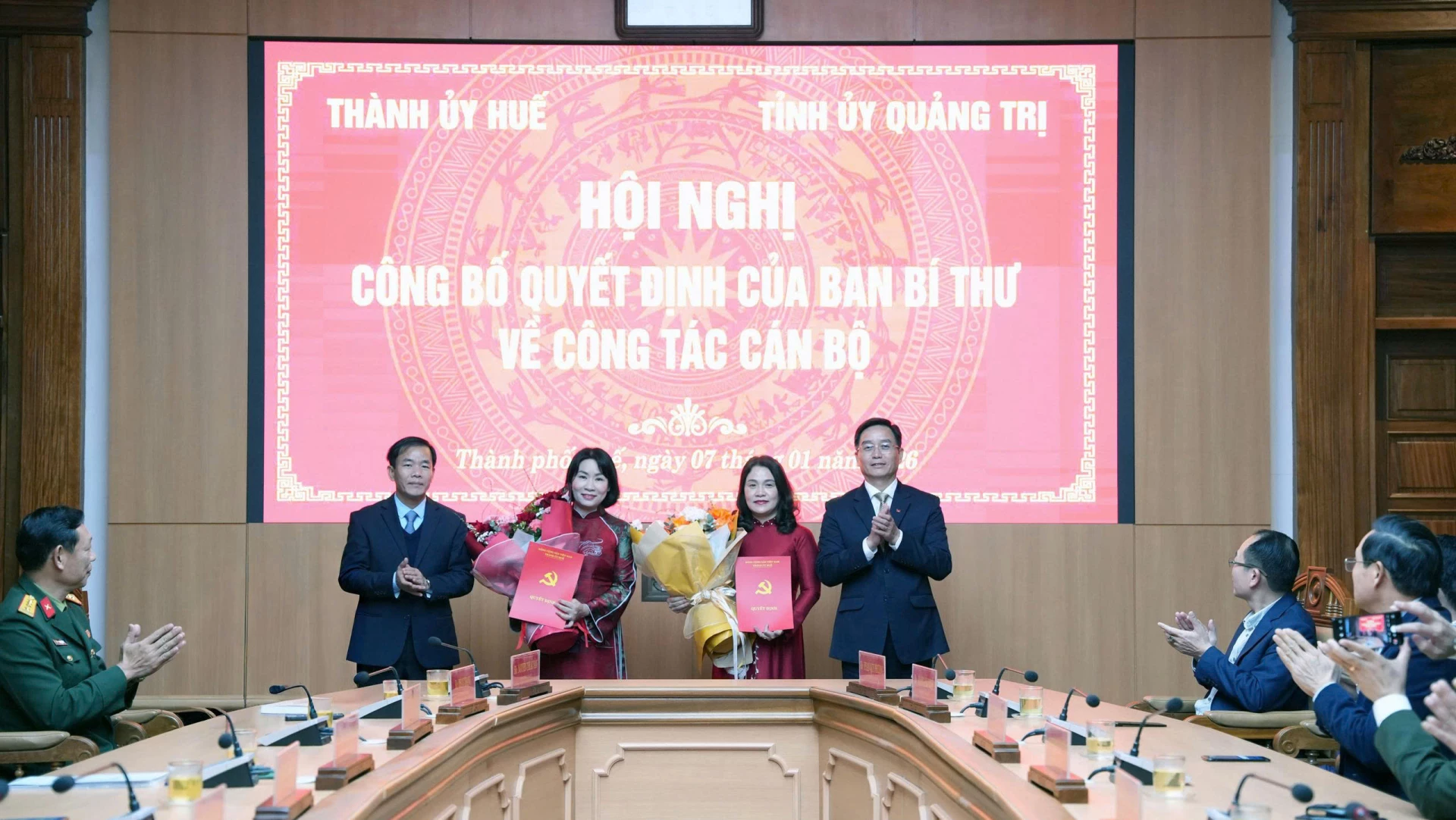 Đồng chí Nguyễn Đình Trung, Bí thư Thành uỷ Huế và đồng chí Nguyễn Văn Phương, Bí thư Tỉnh uỷ Quảng Trị trao quyết định và tặng hoa chúc mừng đồng chí Hồ Thị Thu Hằng và đồng chí Phạm Thị Minh Huệ - Ảnh: QV
