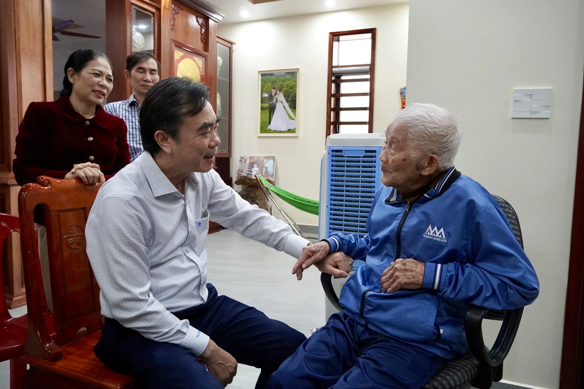 Đồng chí Nguyễn Lương Bình trò chuyện với đồng chí Nguyễn Đổng, đảng viên 80 năm tuổi Đảng - Ảnh: H.N