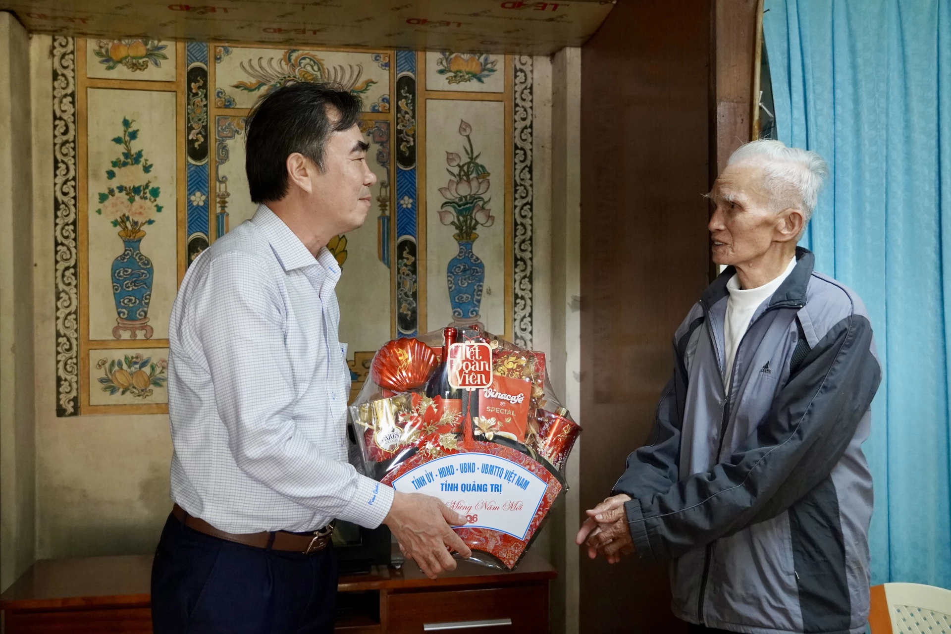 Đồng chí Nguyễn Lương Bình tặng quà cho ông Nguyễn Thanh Chuẩn, thương binh, xã Nam Trạch - Ảnh: H.N