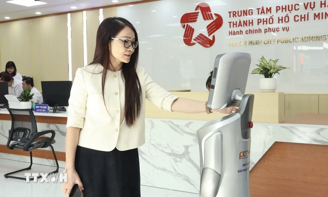 Robot lễ tân hướng dẫn người dân đến đúng khu vực làm thủ tục theo lĩnh vực. (Ảnh: Xuân Anh/TTXVN)