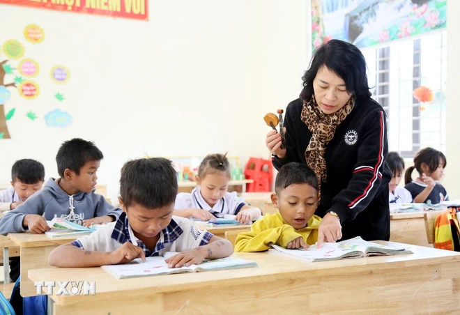 Em Hồ Kay (áo vàng), học sinh điểm trường K Ai (xã Dân Hóa) thường xuyên nghỉ học nên luôn được giáo viên kèm cặp, bổ sung kiến thức. (Ảnh: Tá Chuyên/TTXVN)