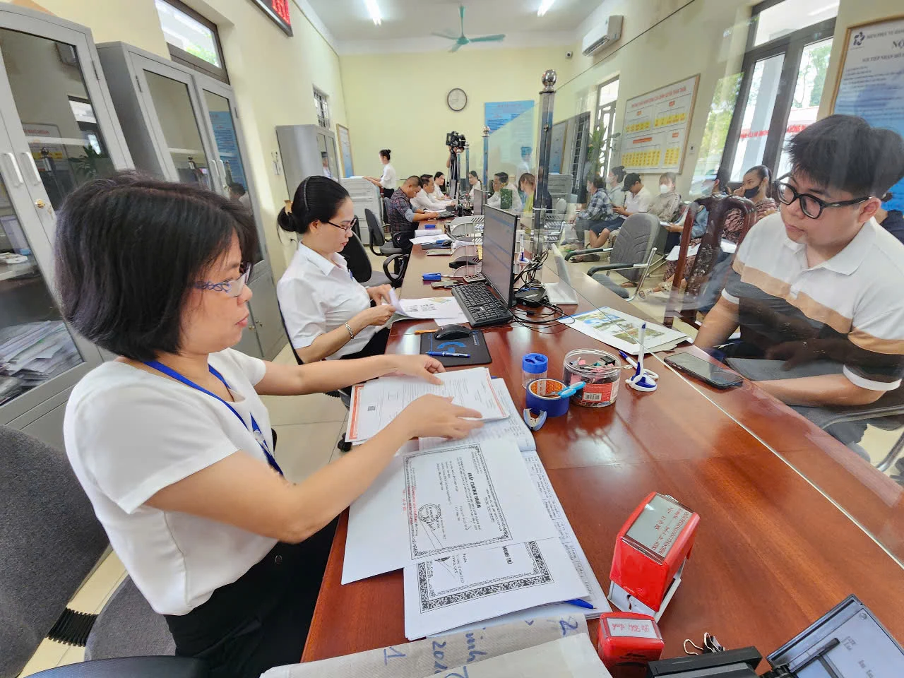 Cán bộ Trung tâm Phục vụ hành chính công xã Thiên Lộc (Hà Nội) hướng dẫn người dân giải quyết thủ tục hành chính.