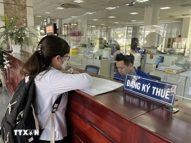 Người dân thực hiện giao dịch tại Cục Thuế. (Ảnh: Hứa Chung/TTXVN)