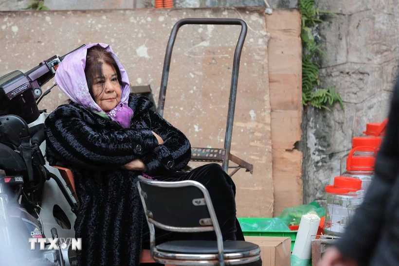 Một người bán hàng co ro trong tiết trời lạnh. (Ảnh: Hoàng Hiếu/TTXVN)Một người bán hàng co ro trong tiết trời lạnh. (Ảnh: Hoàng Hiếu/TTXVN)