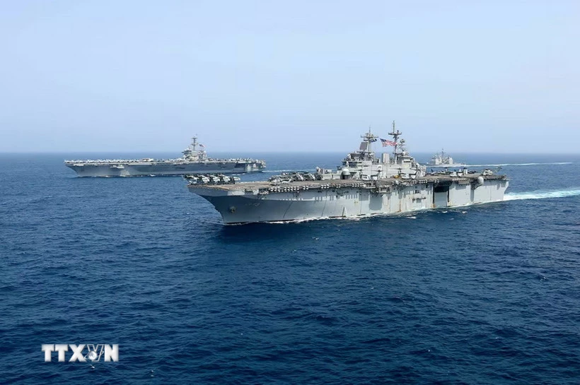Tàu sân bay USS Abraham Lincoln (phía sau) của hải quân Mỹ di chuyển trên Biển Arab. (Ảnh: AP/TTXVN)