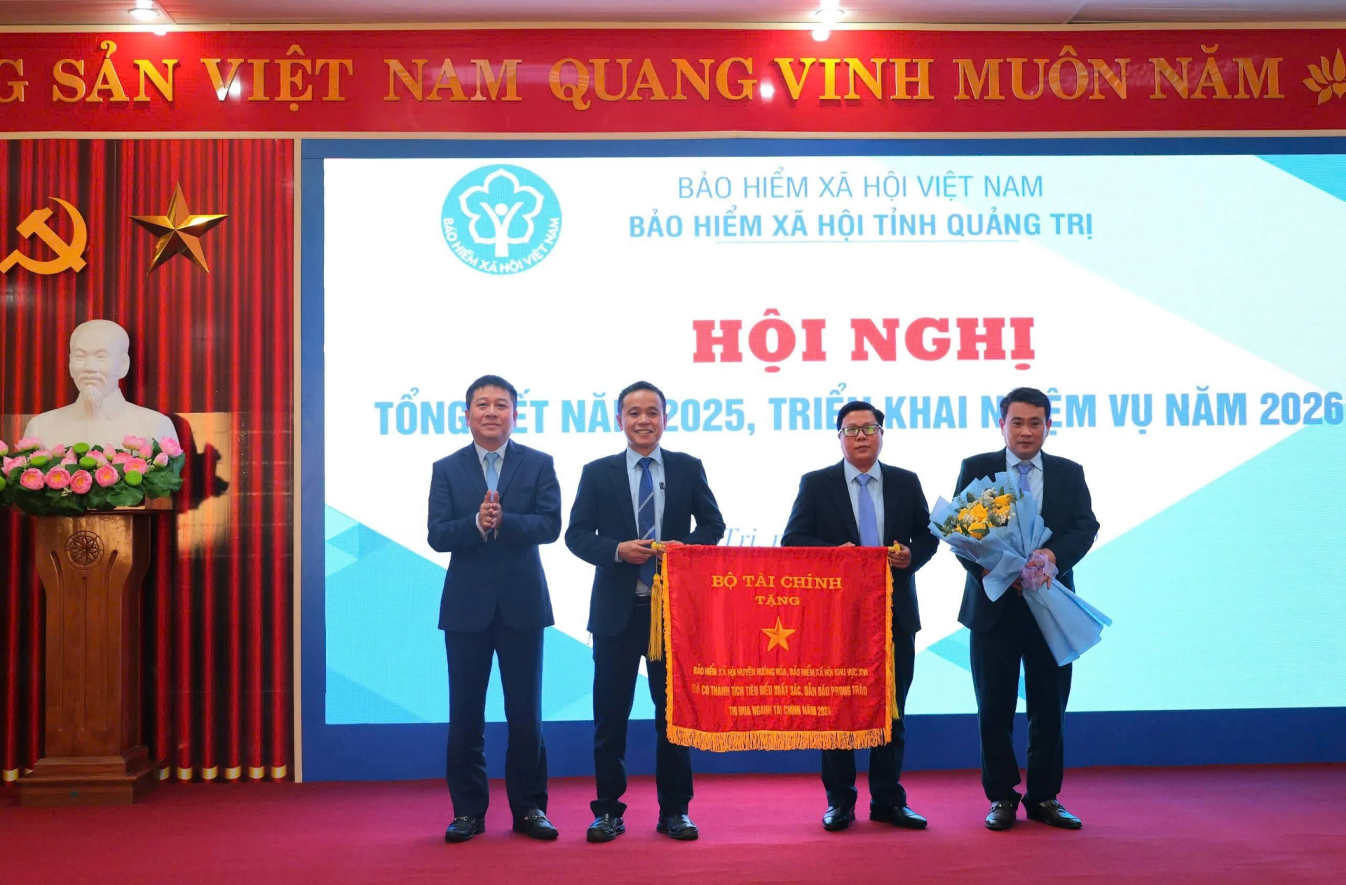 Giám đốc Bảo hiểm xã hội tỉnh Trần Anh Tuấn trao tặng Cờ thi đua của Bộ Tài chính cho tập thể Bảo hiểm xã hội cơ sở Khe Sanh - Ảnh: N.L