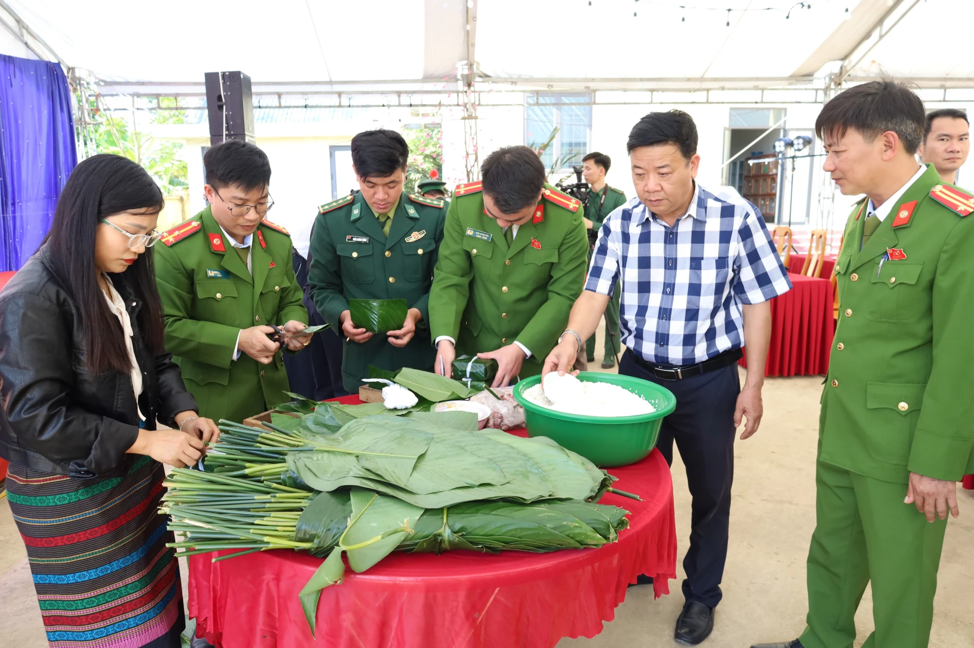Cán bộ, chiến sĩ Bộ đội Biên phòng, Công an xã Dân Hóa cùng bà con dân bản gói bánh chưng tại Ngày hội “Xuân Biên phòng – Ấm lòng dân bản” ở xã Dân Hóa - Ảnh: Quang Ngọc