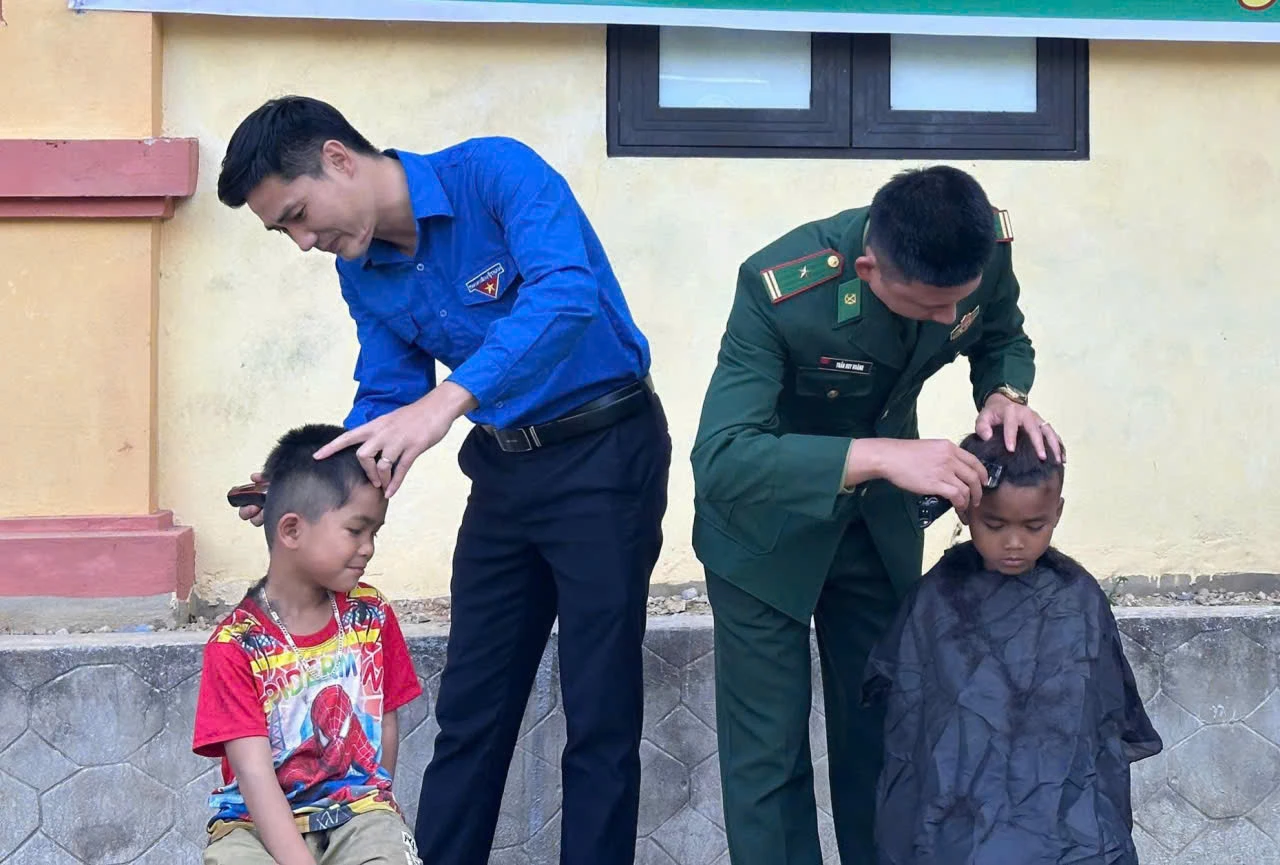 Các lực lượng cắt tóc cho các em nhỏ bản chân Trộông - Ảnh: X.V
