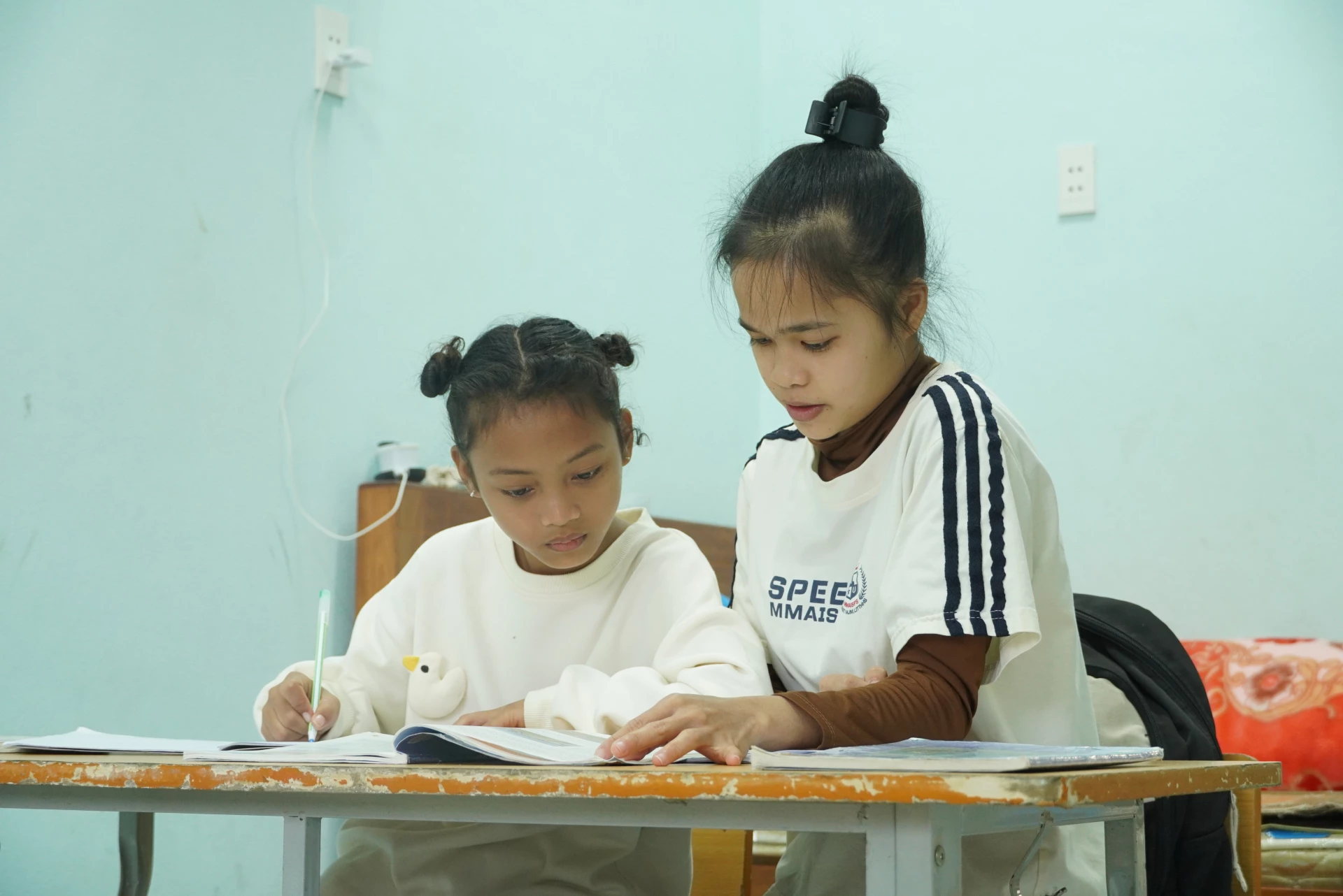 Từ trẻ mồ côi, em Hồ Phương Tâm (bên trái) đã có một mái ấm nhiều yêu thương - Ảnh: H.L