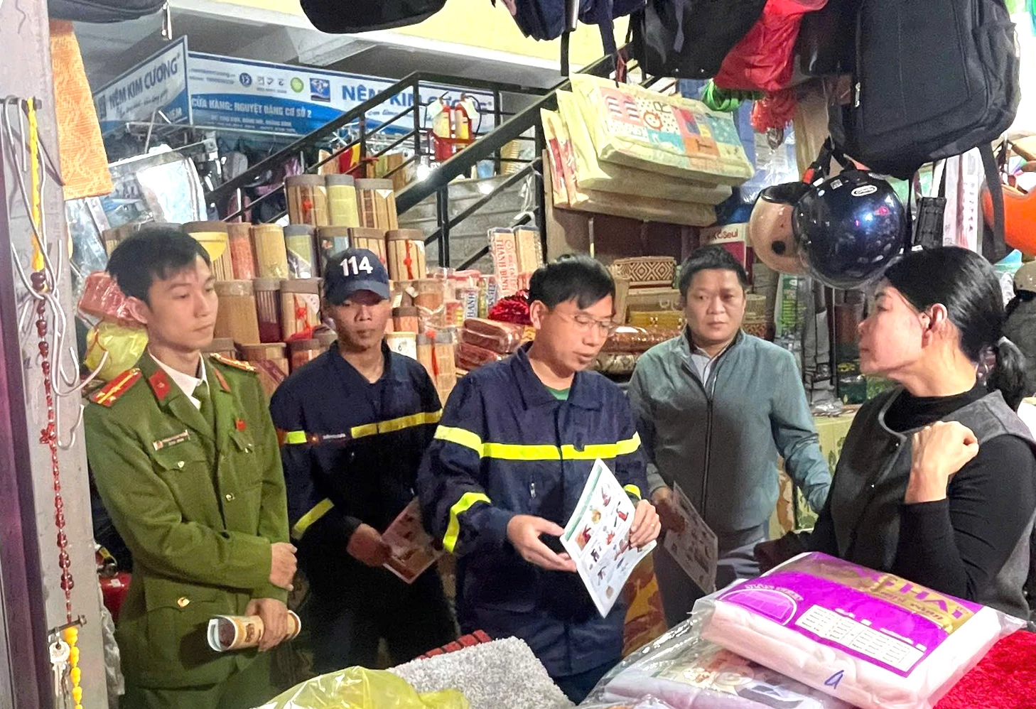 Hướng dẫn quét mã QR tiếp cận kiến thức về PCCC và CNCH cho tiểu thương tại các quầy kinh doanh - Ảnh: CTV.