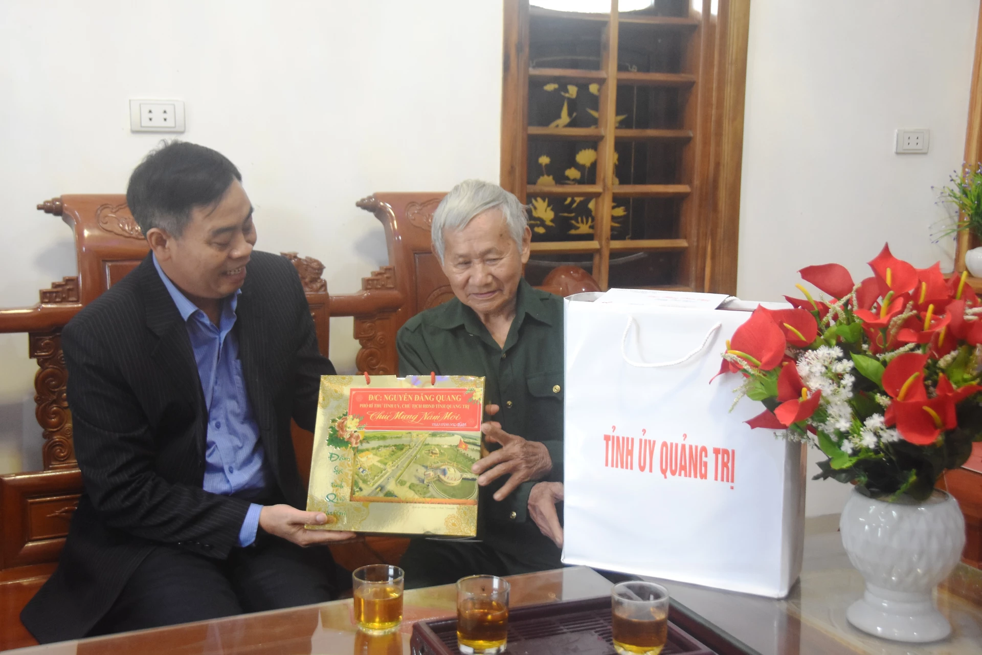 Đồng chí Nguyễn Đăng Quang, Phó Bí thư Tỉnh ủy, Chủ tịch HĐND tỉnh tặng quà Tết cho ông Võ Văn Đáp, 83 tuổi, thương binh 65% ở thôn 7, xã Vĩnh Linh - Ảnh: ĐV