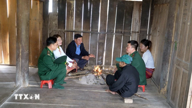 Lực lượng biên phòng và các già làng, trưởng bản đến từng hộ gia đình người Chứt ở bản Rào Tre để tuyên truyền về công tác bầu cử. (Ảnh: Hữu Quyết/TTXVN)