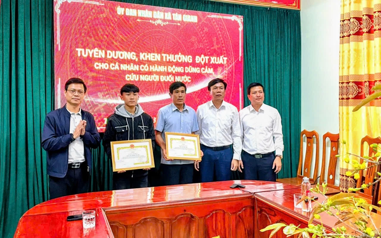 Lãnh đạo xã Tân Gianh trao giấy khen ghi nhận hành động dũng cảm cứu người của hai cha con ông Cao Hữu Tình và em Cao Hoàng Ân Đức - Ảnh: T.G