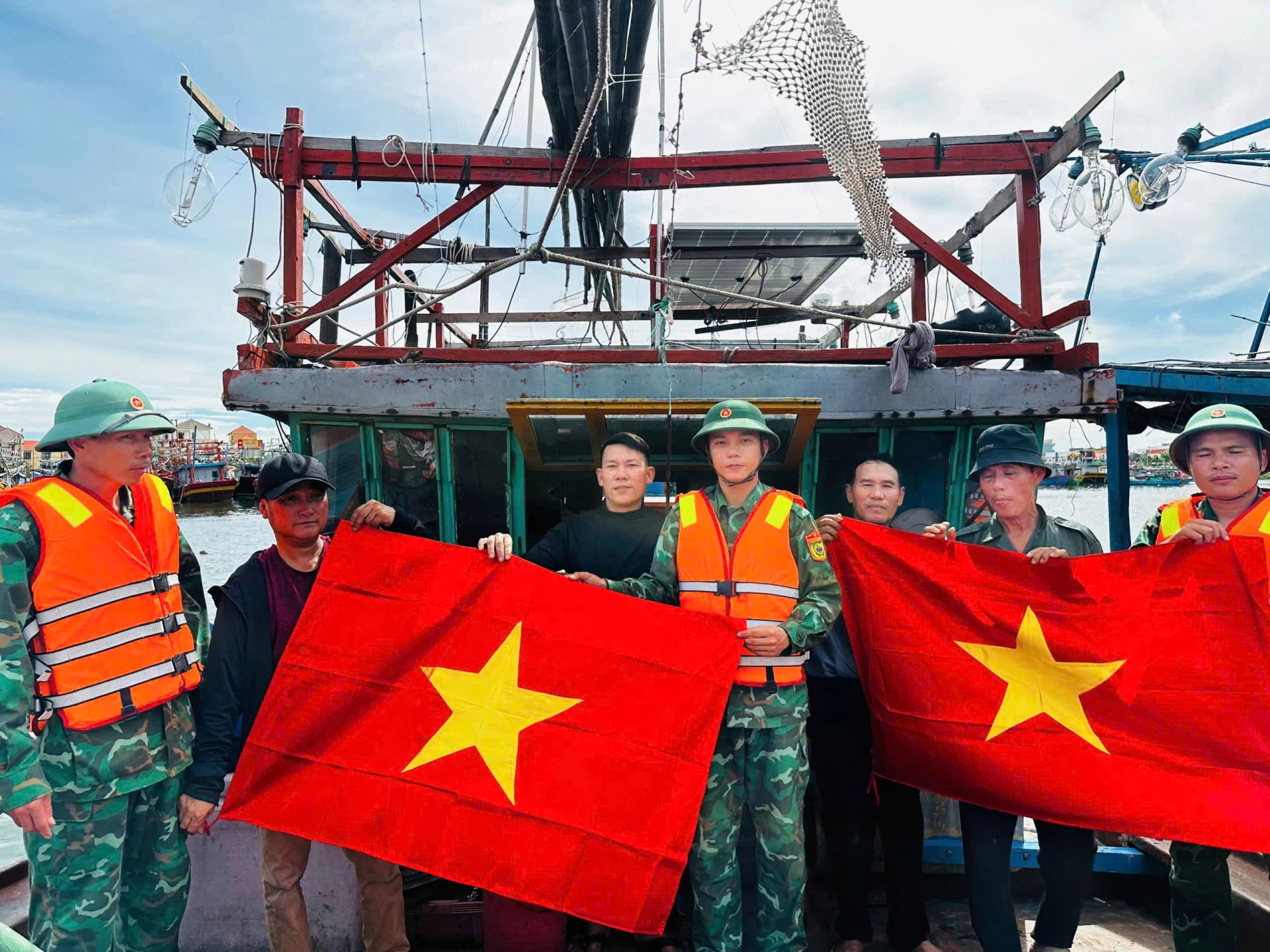 Lực lượng chức năng về cơ sở tặng cờ Tổ quốc và tuyên truyền  ngư dân về chống khai thác IUU - Ảnh: N.M.P