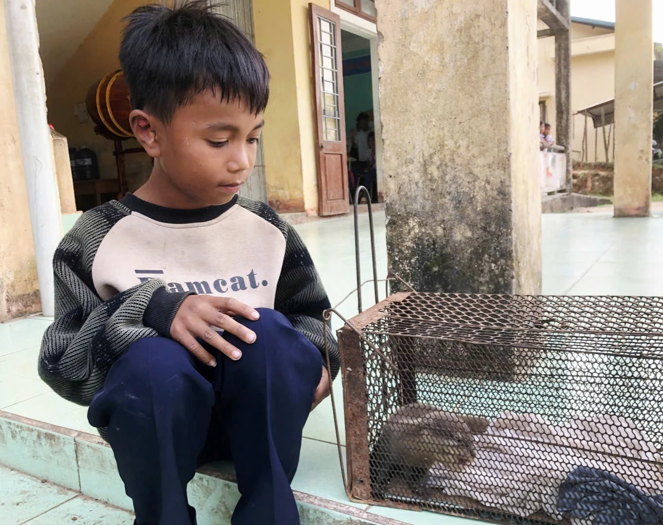 Em Hồ Văn Xiếc, học sinh lớp 4C, Trường Tiểu học Tà Long bên cá thể rái cá vừa được em phát hiện và bảo vệ-Ảnh: K.S