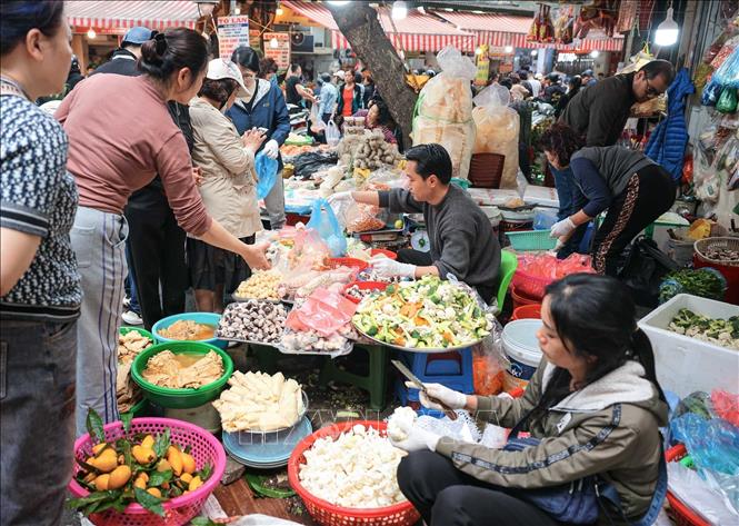 Nhiều người dân có thói quen đi chợ để sắm sửa thực phẩm chuẩn bị cho mâm cơm cúng tất niên và lễ cúng giao thừa, thể hiện lòng thành kính với tổ tiên. Ảnh: Hoàng Hiếu/TTXVN
