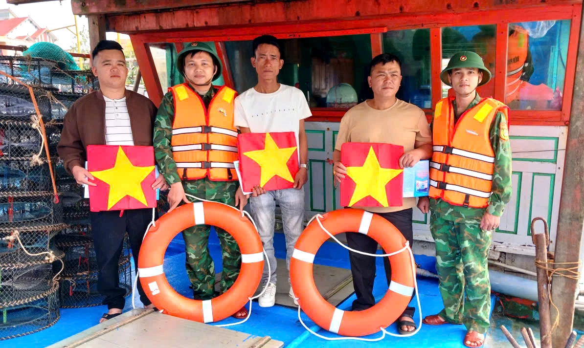 Đồn Biên phòng Nhật Lệ phối hợp tặng cờ Tổ quốc, áo phao động viên ngư dân - Ảnh: ĐBP 