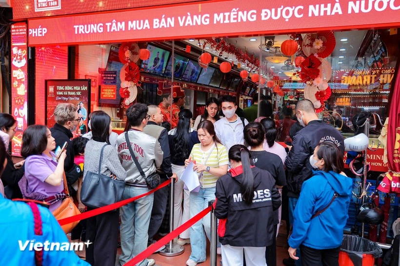 Người dân xếp hàng trật tự chờ đến lượt giao dịch trong ngày vía Thần Tài tại cửa hàng trên phố Cầu Giấy (Hà Nội). (Ảnh: Lê Đông/TTXVN)