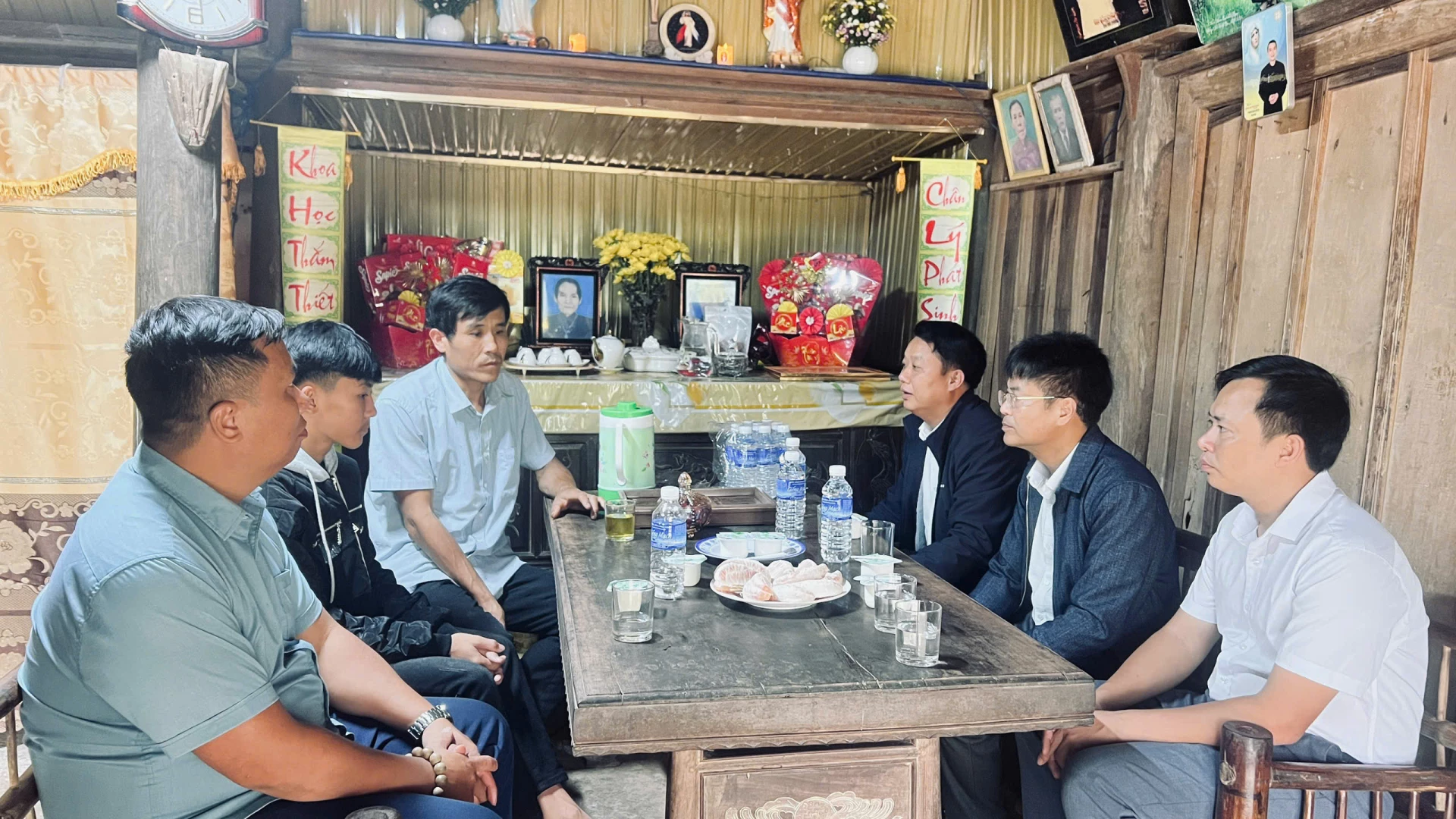 Lãnh đạo xã trò chuyện cùng các thành viên trong gia đình ông Cao Hữu Tình - Ảnh: Nh.V