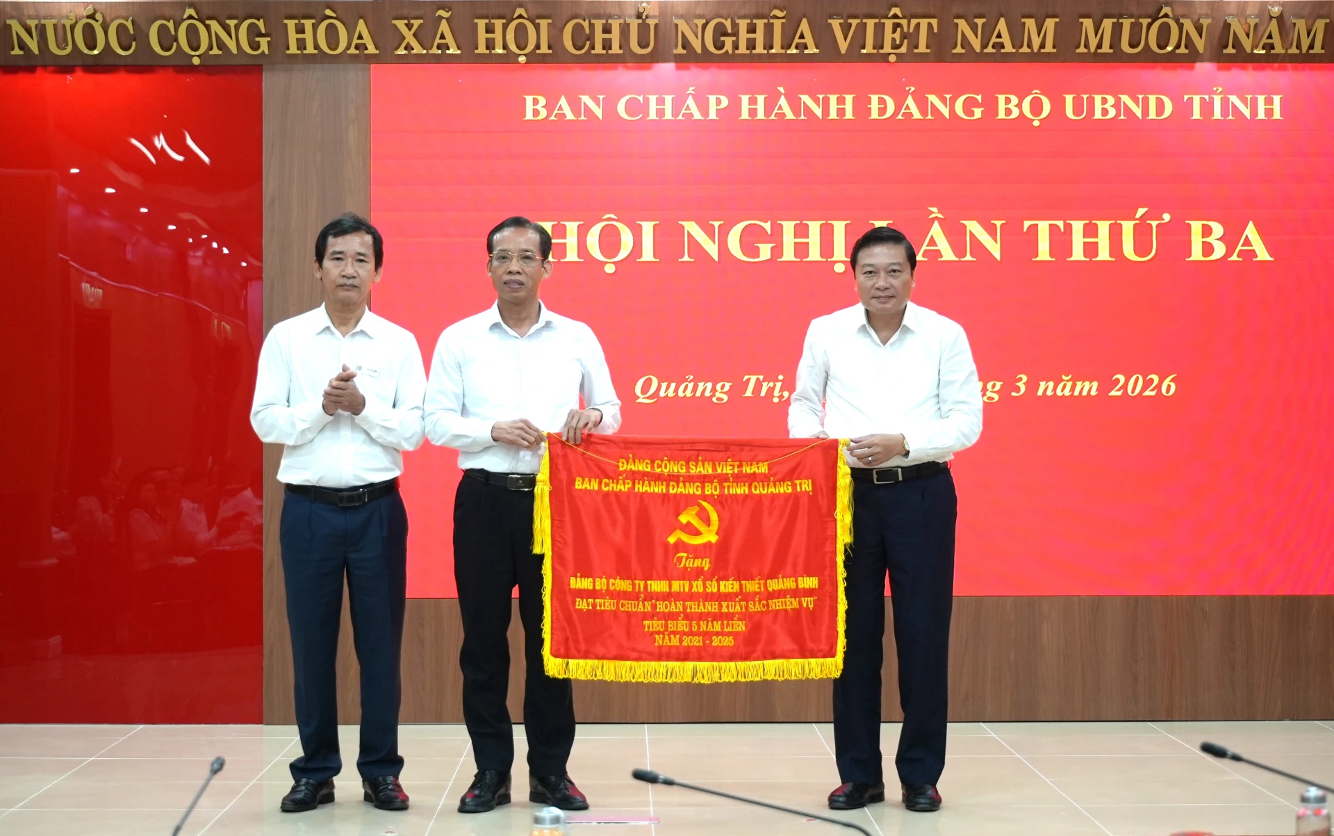Đồng chí Lê Hồng Vinh, Phó Bí thư Tỉnh ủy, Chủ tịch UBND tỉnh trao cờ của Ban Thường vụ Tỉnh ủy cho Đảng bộ Công ty TNHH MTV Xổ số kiến thiết Quảng Bình - Ảnh: T.Đ