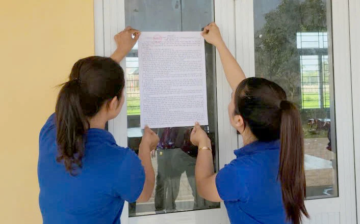 Đoàn viên, thanh niên xã Hiếu Giang hỗ trợ niêm yết danh sách cử tri - Ảnh: P.V