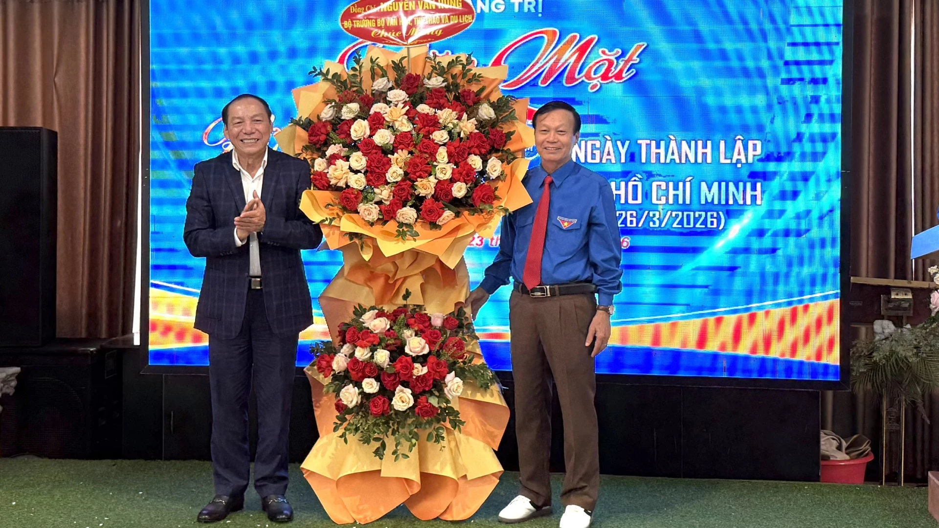 Đồng chí Nguyễn Văn Hùng, Bộ trưởng Bộ Văn hóa, Thể thao và Du lịch tặng hoa chúc mừng buổi gặp mặt - Ảnh: NL