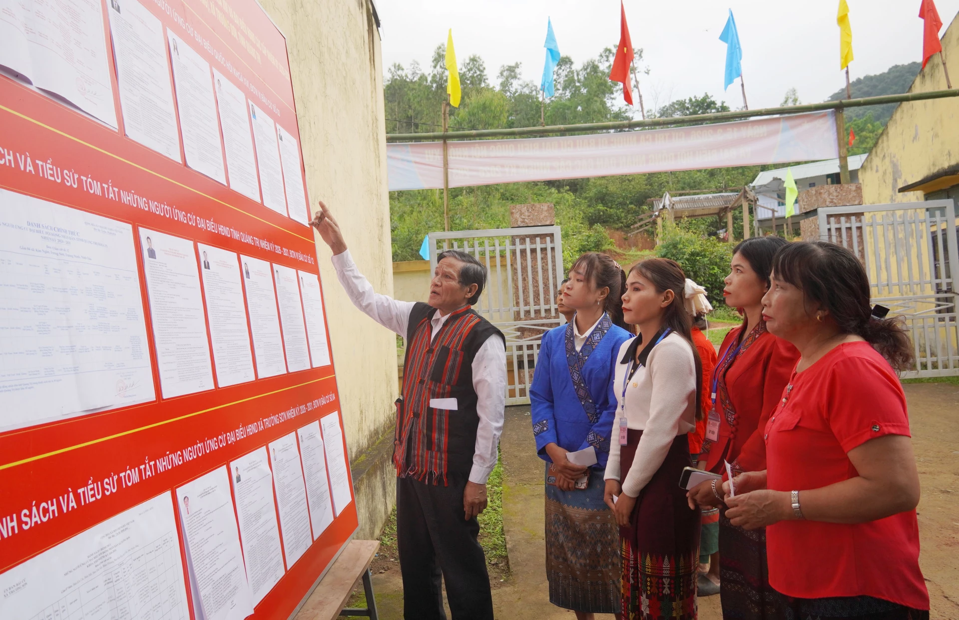 Bà con cử tri người Vân Kiều xem danh sách niêm yết các ứng cử viên đại biểu Quốc hội và HĐND các cấp - Ảnh: X.P