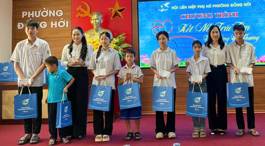 Đại diện lãnh đạo phường Đồng Hới và Hội LHPN phường trao quà cho các học sinh có hoàn cảnh khó khăn trong chương trình “Kết nối yêu thương”-Ảnh: H.Tr.