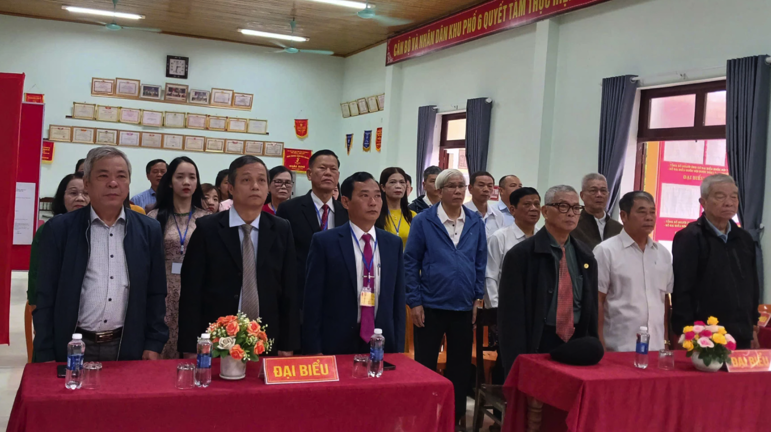 Các đại biểu và cử tri thực hiện nghi thức chào cờ khai mạc bầu cử - Ảnh: N.B