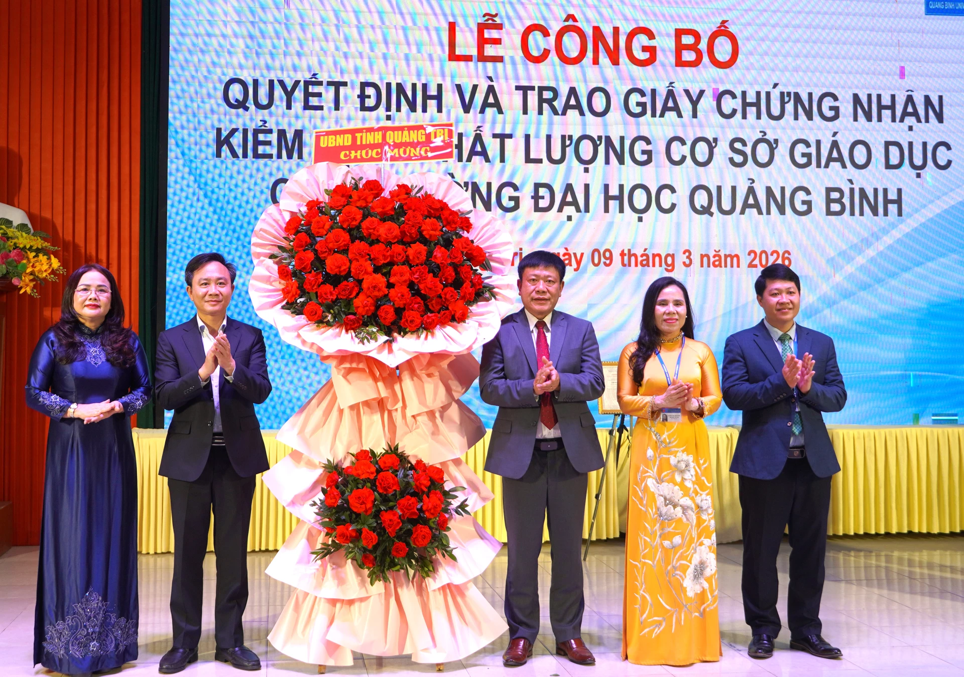 Đồng chí Phó Chủ tịch UBND tỉnh Hoàng Xuân Tân tặng hoa chúc mừng Trường đại học Quảng Bình - Ảnh: H.Tr.