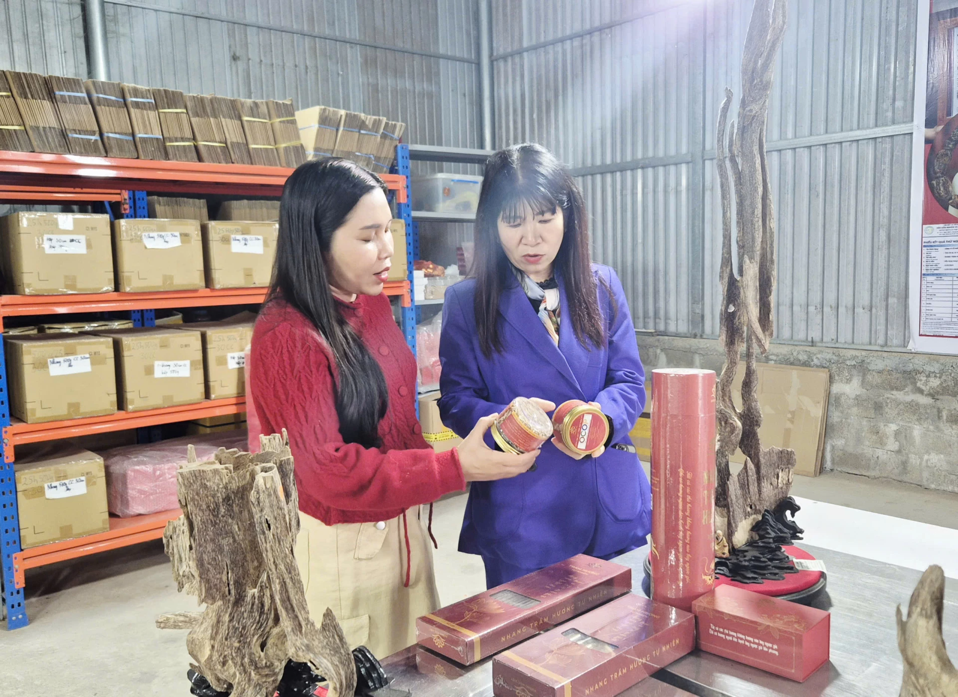 Chị Ái (bên trái) giới thiệu sản phẩm đạt chứng nhận OCOP và tiêu chuẩn ISO của công ty - Ảnh: K.S