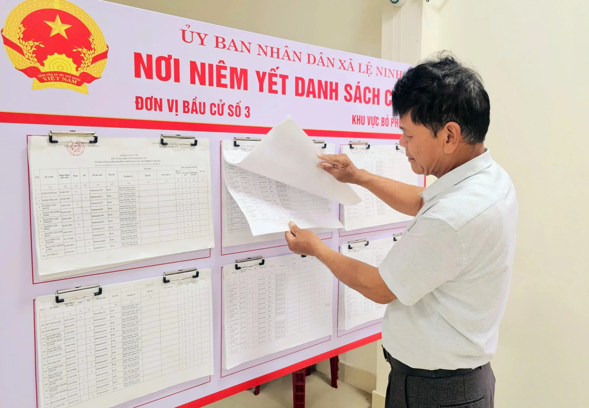 Người dân cập nhật, theo dõi danh sách cử tri được niêm yết tại đơn vị bầu cử số 3-Ảnh: L.C