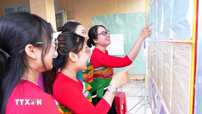 Cử tri xem lại danh sách, tiểu sử tóm tắt các ứng cử viên trước khi tham gia bỏ phiếu tại khu vực bỏ phiếu số 11, ấp Phước Trung, xã Long Chữ, tỉnh Tây Ninh. (Ảnh: Minh Phú/TTXVN)