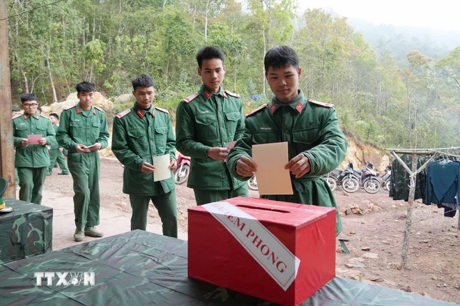 Các chiến sĩ Tiểu đoàn 1, Lữ đoàn 543, Quân khu 2 tiến hành bỏ phiếu vào thùng phiếu phụ của Tổ bầu cử số 1, xã Sín Thầu, tỉnh Điện Biên. (Ảnh: Trung Kiên/TTXVN)
