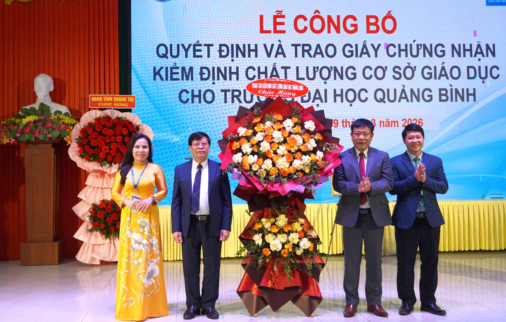 Giám đốc Trung tâm Kiểm định chất lượng giáo dục Thăng Long Nguyễn Văn Đường tặng hoa chúc mừng Trường đại học Quảng Bình - Ảnh: H.Tr.