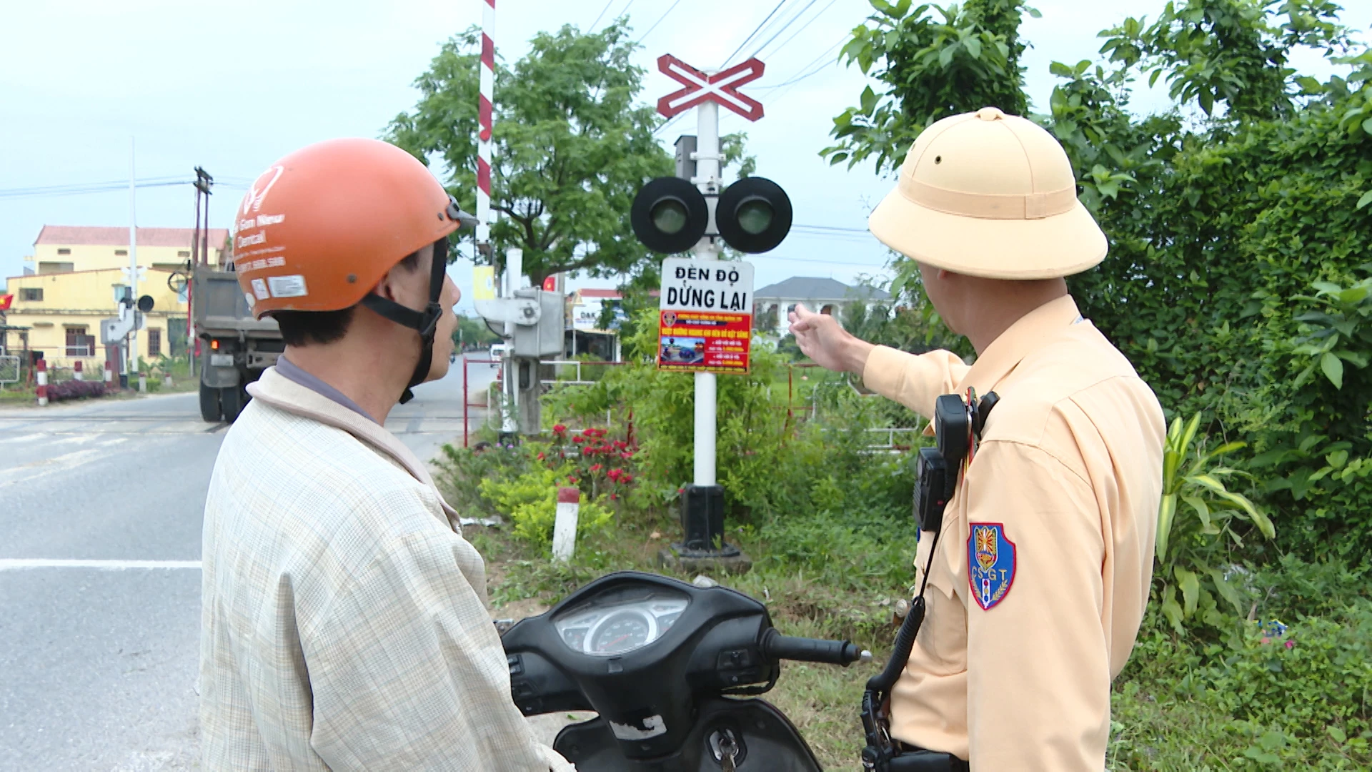 Lực lượng cảnh sát giao thông tuyên truyền nâng cao ý thức người dân khi tham gia giao thông qua đường ngang - Ảnh: LT
